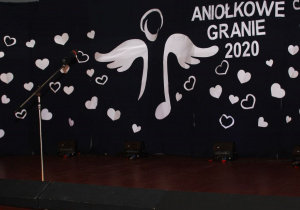 Dekoracja sceny przedstawiająca postać anioła otoczonego sercami i napisem akcji charytatywnej Aniołkowe granie