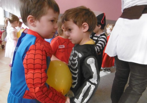 Spaidermen i szkieletor tańczą trzymając brzuszkami balon.