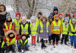 Grupowe zdjęcie dzieci z nauczycielkami w zimowej aurze.