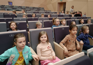 Dzieci siedzą na widowni w sali koncertowej