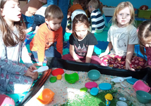Dzieci eksperymentują z kolorowymi posypkami o róznych kształtach