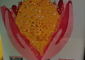 Plakat fundacji Góra Grosza przedstawia kwiat z różowymi płatkami w kształcie dłoni obejmującymi złotą górę