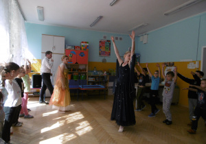 Dziewczynki stoją w szeregu przed oknami naśladuja ruchy pokazywane przez baletnicę w kostiumie dnia. Chłopcy stoja naprzeciwko dziewczynek, nasladuja ruchy baletnicy w kostiumie nocy