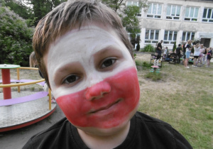 Chłopiec z twarzą flagi polskiej, pomalowaną w kolorach: biały na górze, czerwony na dole
