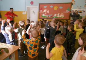 Dzieci wspólnie z kubańskim tancerzem wykonują ćwiczenia odechowe.