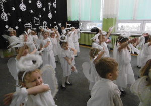 Dzieci-aniołki tańczą na scenie.