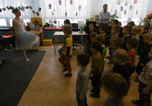 Baletnica pokazuje dzieciom jakie ruchy mają wykonywać.