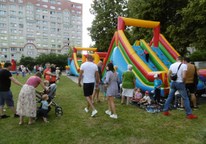 Uczestnicy pikniku idą w stronę dmuchańców.