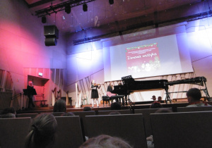 Nauczycielka gra na fortepianie, uczennica gra na skrzypcach.