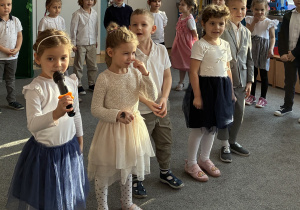 Trzy dziewczynki i dwóch chłopców recytuje wiersz.