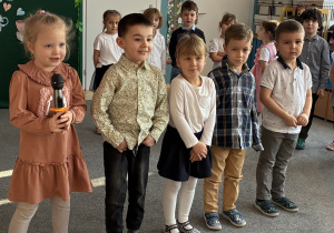 Dwie dziewczynki i trzech chłopców recytuje wiersz.